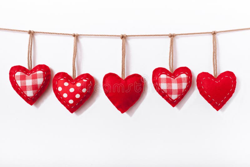 Valentine background. Red hearts hanging on white background