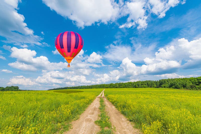 Colorful Hot Air Balloon Flying Over Green Field Stock Photo - Image of ...