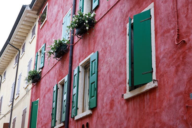 Red house facade with green colored window shutters