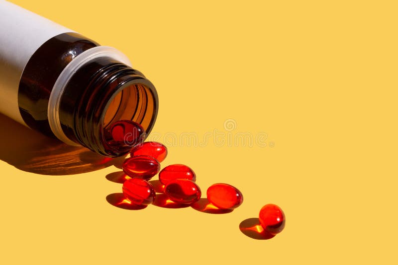 Red Jelly Capsules With Vitamin E, Poured From A Bottle Stock Image