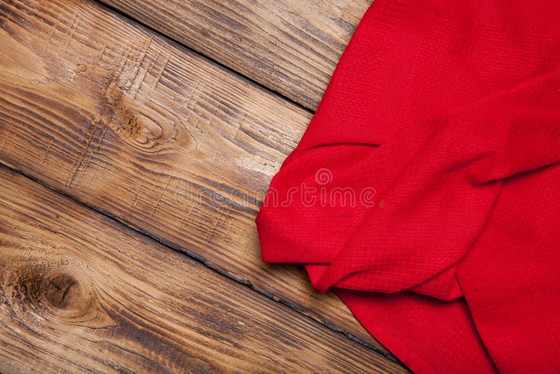 Red kitchen towel on old wooden burned table or board for background