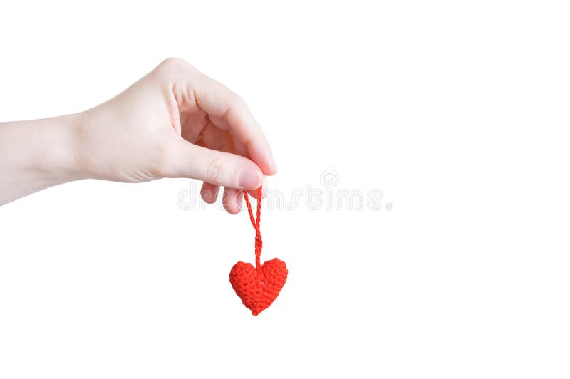 Red knitted heart in the hand of caucasian girl close-up. White isolate stock photos Red knitted heart in the hand of caucasian girl close-up. White isolate stock photos