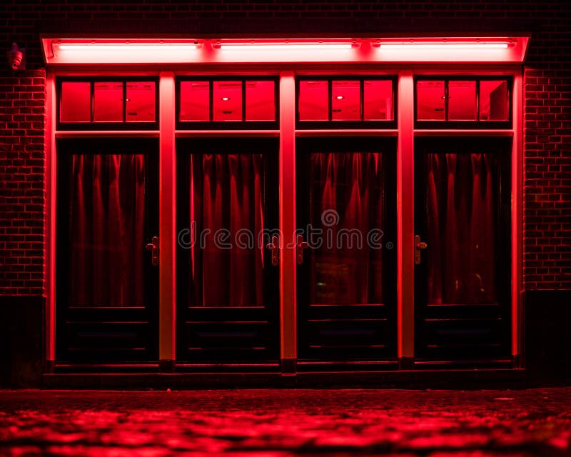 Red Light District in Amsterdam. Red boxes with curtains and wet Cobbles on the street stock photo Red Light District in Amsterdam. Red boxes with curtains and wet Cobbles on the street stock photo
