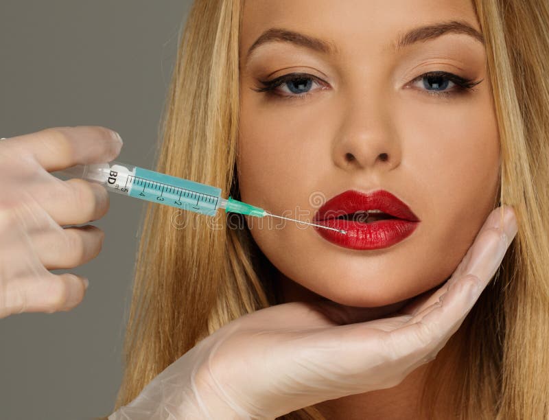 Red lips with Botox syringe royalty free stock photography Red lips with Botox syringe royalty free stock photography