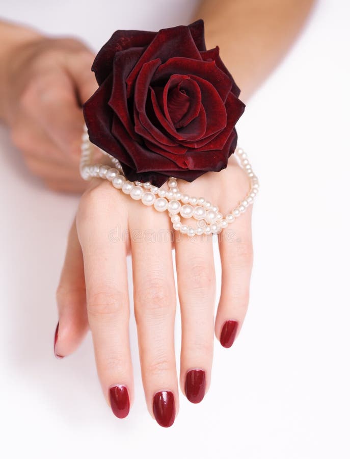 Mujer hermosa mano, joyas a rosa roja.