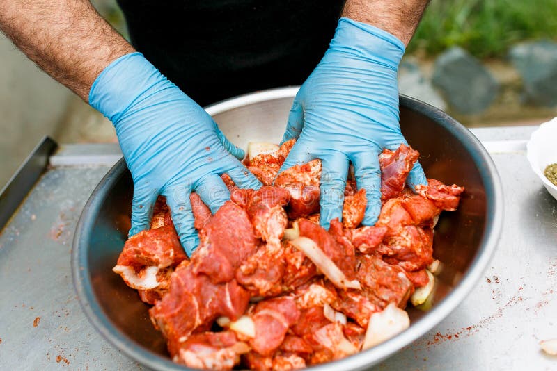 Red meat is mixed in a barbecue marinade.