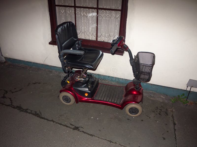 red mobility scooter parked outside in front of house disability