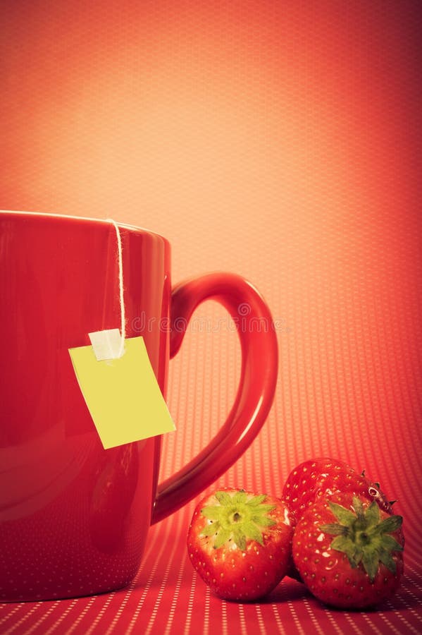 P con la bustina di tè e fragole su sfondo rosso come il tè di frutta concetto, bevande calde, inverno caldo, bevande, succo di frutta, tè bustina di tè.