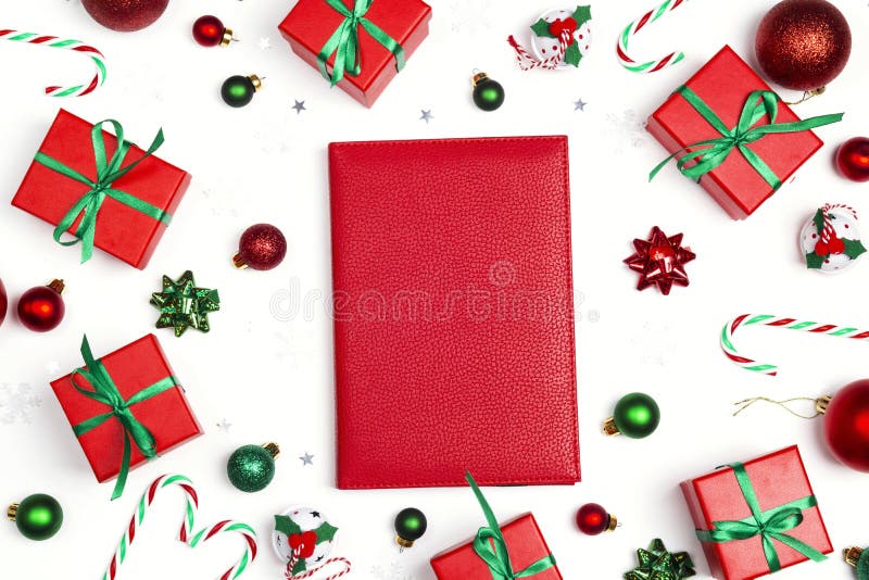 Red notebook with Christmas composition of gifts and decoration on a white background