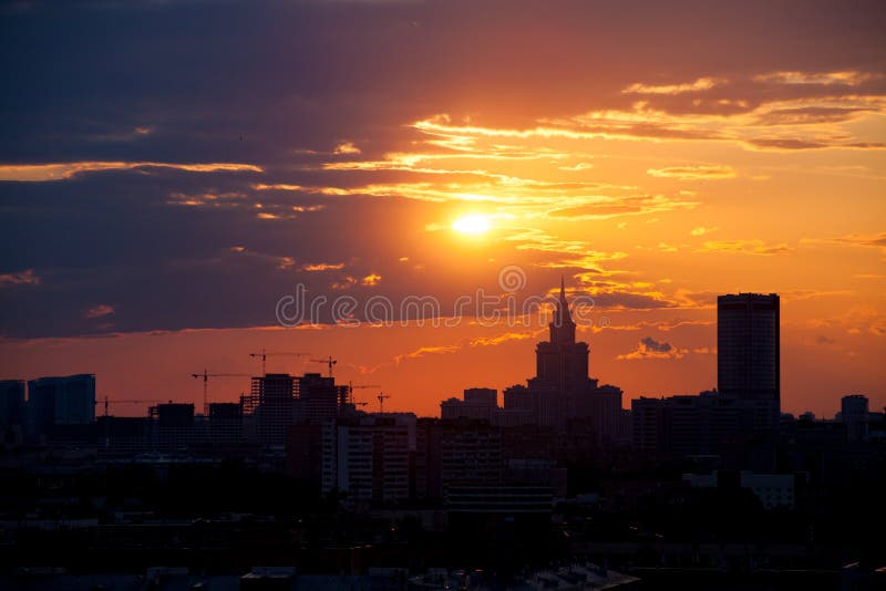 Red and orange sky with clouds and silhouette of cranes, construction and a skyscraper. Moscow stock image Red and orange sky with clouds and silhouette of cranes, construction and a skyscraper. Moscow stock image