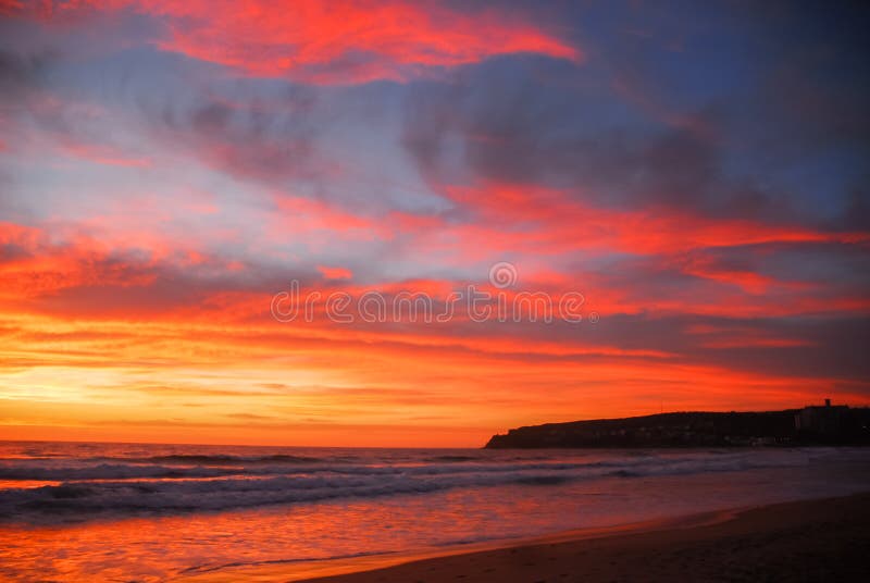 Red and orange sun rise over beach