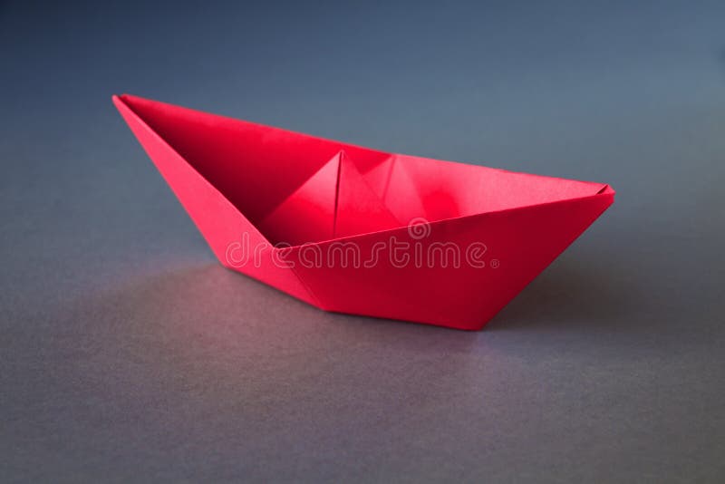 Red Paper Boat Origami Isolated on a Grey Background Stock Photo