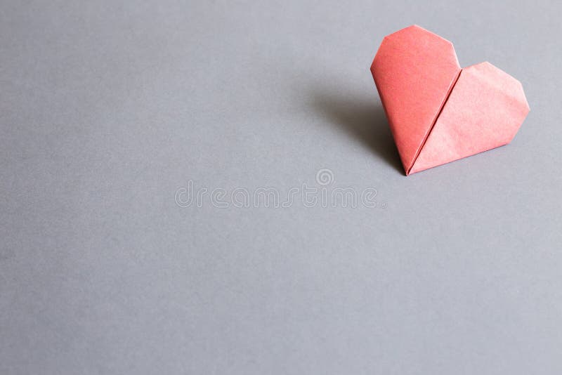 Red paper heart origami on gray background