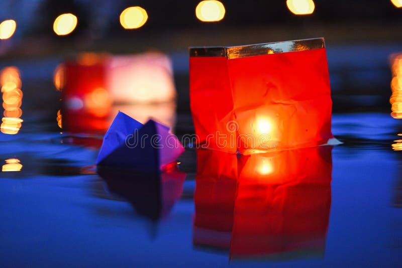 Red paper lanterns floating in dark water at night