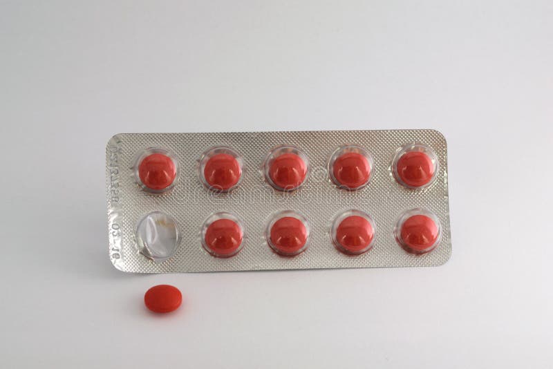 Red pills blister isolated. One pill is removed from tha pack. stock image