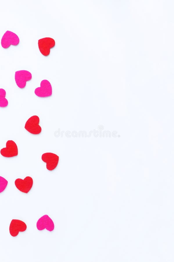 Red and pink felt hearts on a white background. Valentine`s day symbol, holiday concept. Top view with copy space for text