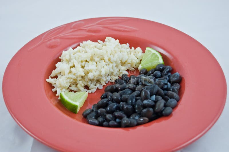 Red Plate of Brown Rice and Black Beans with Lime