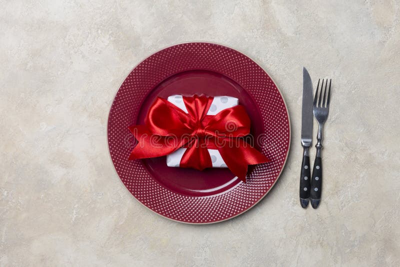 Red Plate with Gift Box, with Fork, Knife and White Napkin at White
