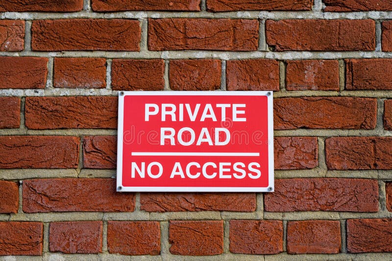 A red private road no access sign on a brick wall stock photo