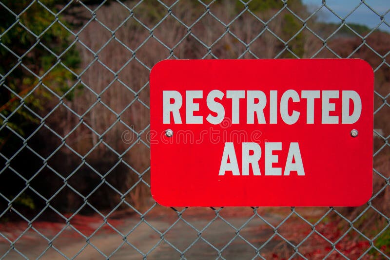 Red Restricted Area Sign on a Chain Link Fence