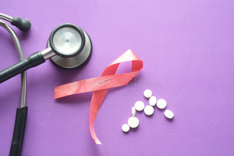 Red ribbon HIV, and stethoscope on purple background. stock image