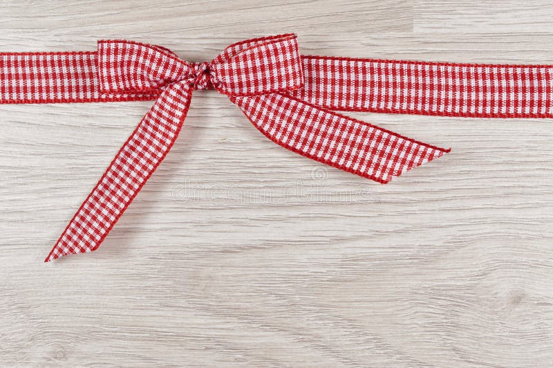 Red ribbon on a wooden background