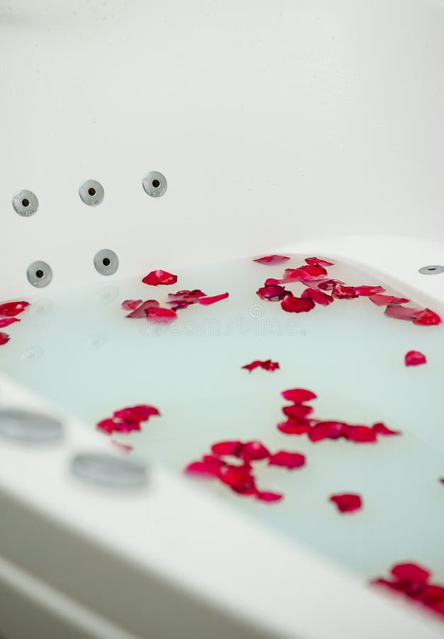 Red rose petals floating in bathtub with milk Stock Photo - Alamy