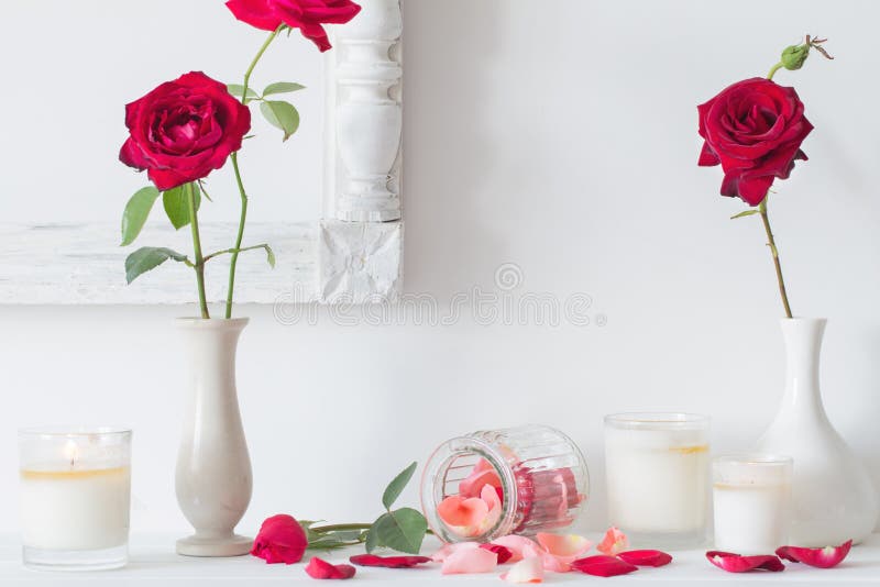 Red roses and candles on white background