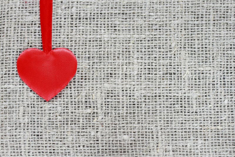 Red Satin Heart on a String Rests on a Background Stock Image - Image ...