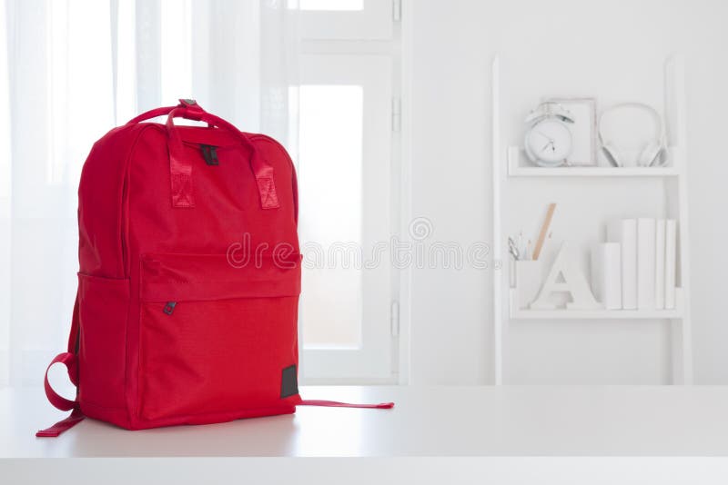 Red school backpack on table in children room interior royalty free stock image