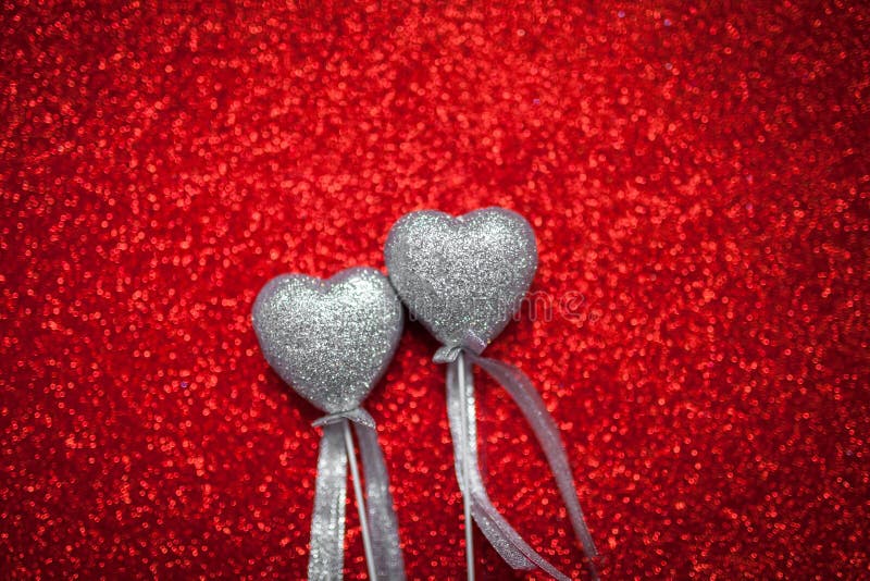 Red shiny background with silver hearts, love, Valentine`s Day, texture abstract background, romantic picture, suitable for adver