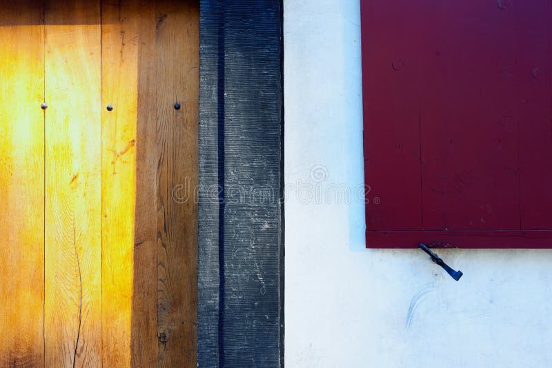 Red shutters and yellow wooden door of an old house