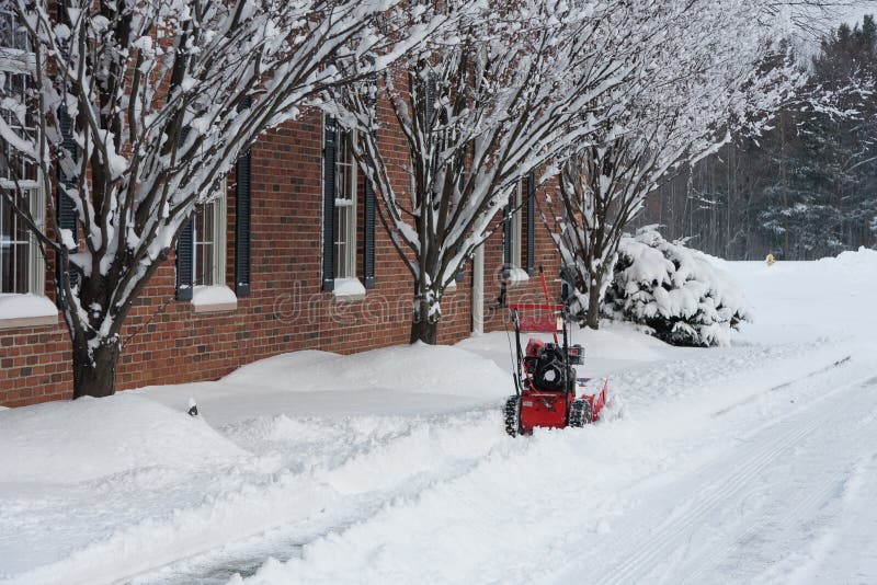 Snowblower near Building and Snow-Covered Trees