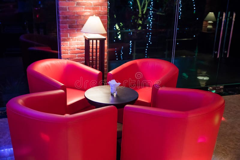 Red Sofa Around Small Table in Lighting from Lamp Stock Photo