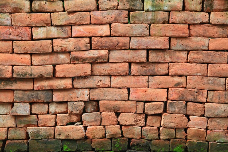 Red stone brick wall with moss