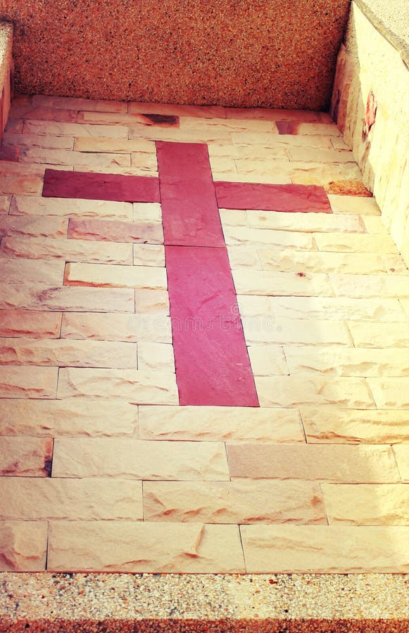 Red Stone Cross of Christ Built into Brick Wall, Vintage Style. Stock