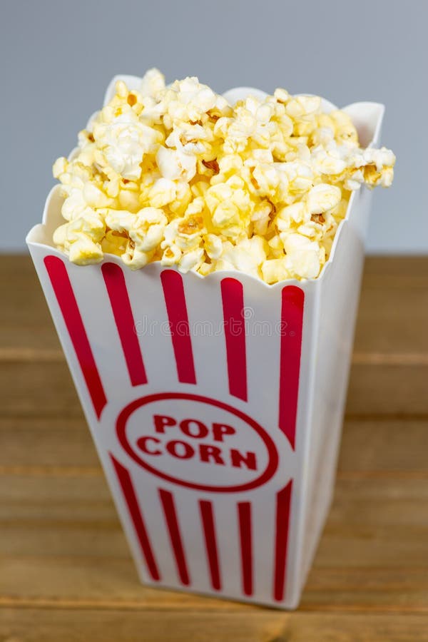 A Red Stripped Popcorn Small Bucket Overflowing with Popcorn Stock