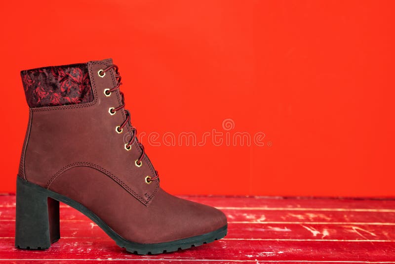 red ones of suede women's half-boot stand on the red floor. Stylish demi-season women's shoes. red ones of suede women's half-boot stand on the red floor. Stylish demi-season women's shoes