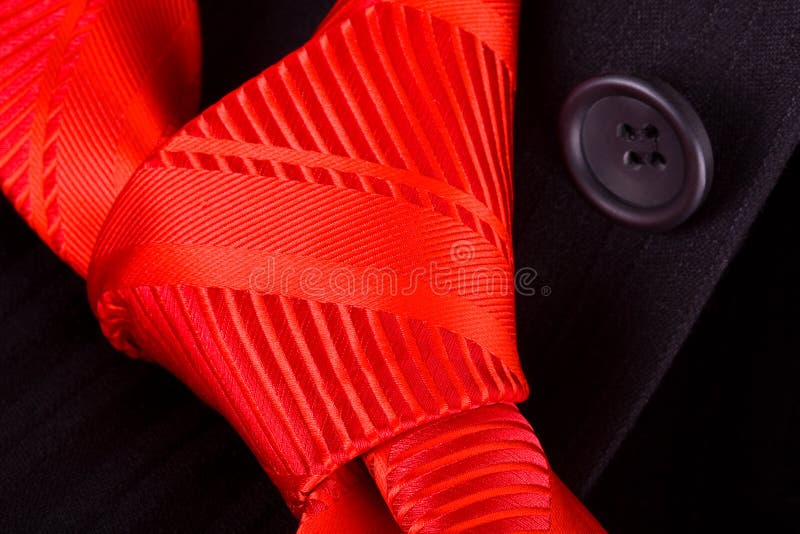 Red tie on a black suit.