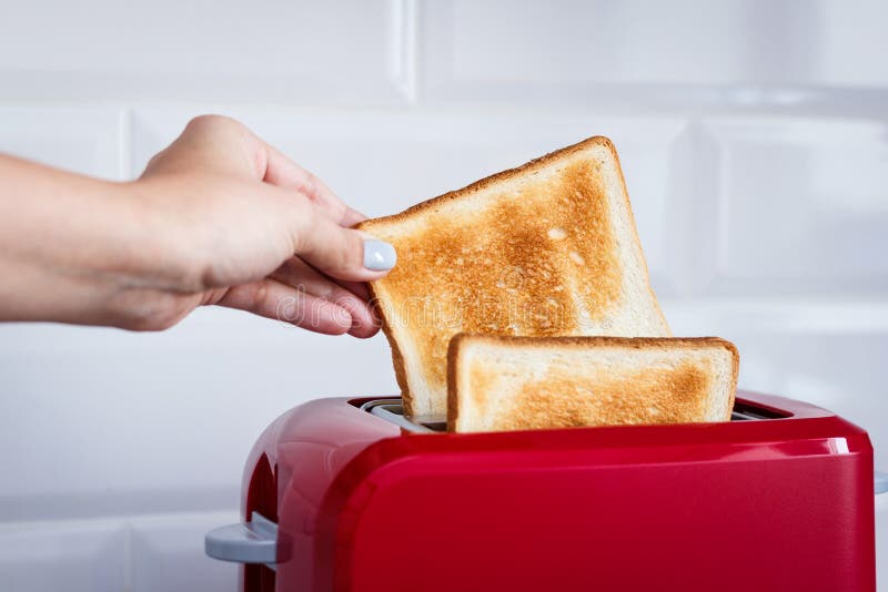 Red Toaster with Toasted Bread for Breakfast Inside. Stock Photo