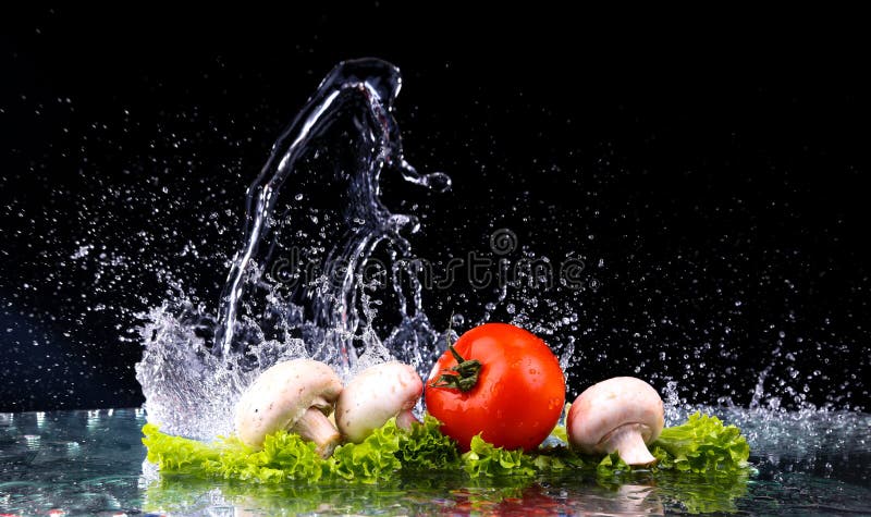 Red tomato cherry, mushrooms and green fresh salad with water drop splash