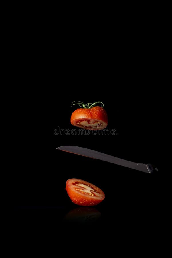 Red tomato cut in half on black background