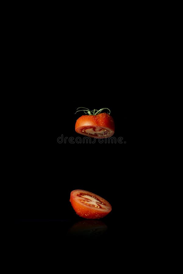 Red tomato cut in half on black background