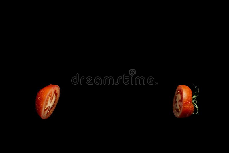Red tomato cut in half on black background