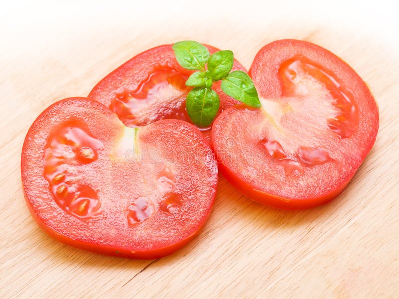 Red tomato slices on chopping board