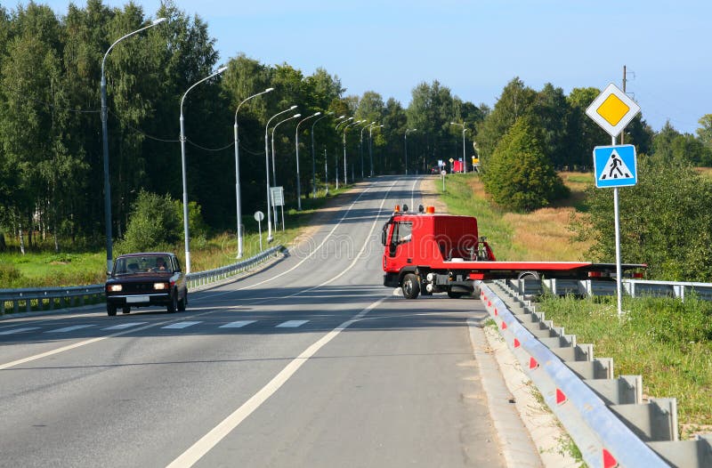 Red tow truck. Road signs