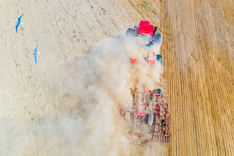 Red tractor cutivating soil on farmland. Aerial landscape. Farming concept royalty free stock photography Red tractor cutivating soil on farmland. Aerial landscape. Farming concept royalty free stock photography