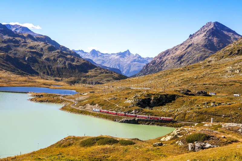 Red Train goes on a mountain road around the lake. stock photo Red Train goes on a mountain road around the lake. stock photo