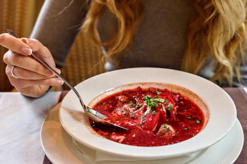 Red Ukranian Beet soup. Girl eating healthy at lunch