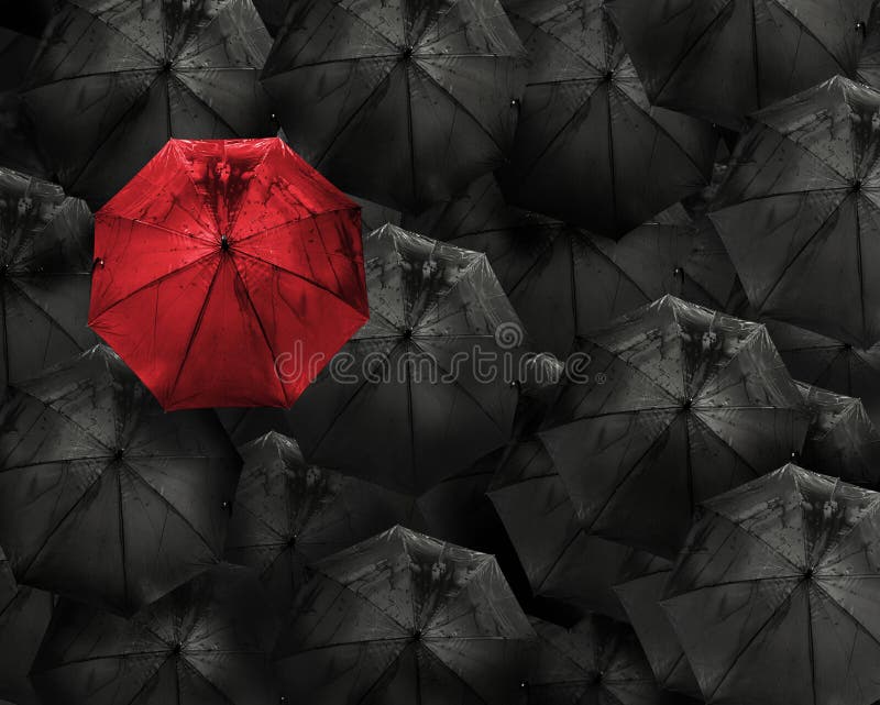 Red umbrella with water drop stand out from the crowd of many bl